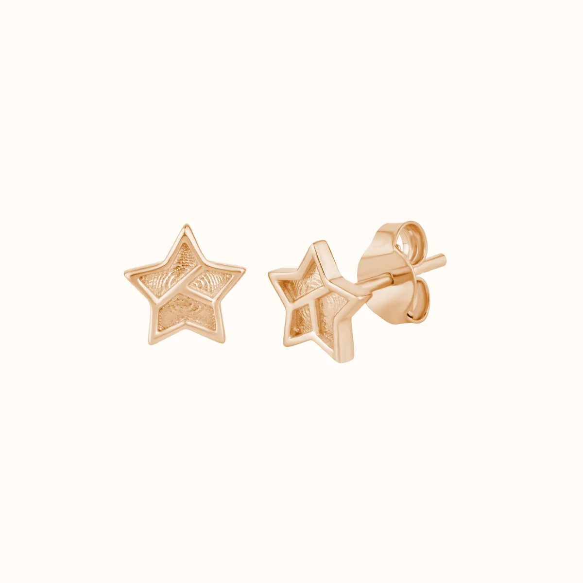 Gold star earrings photographed on a clean studio background