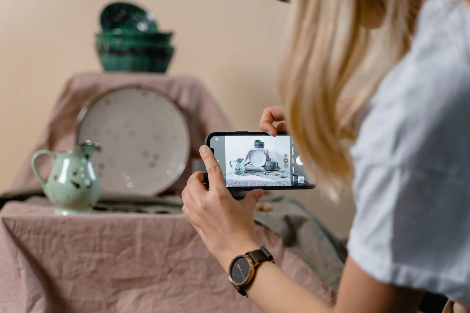 Product photography setup with a person photographing tableware